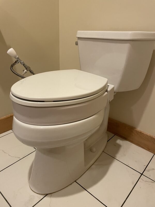 A toilet with the seat up and the lid down.